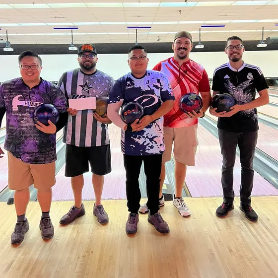 Tournament winners lined up holding their bowling balls